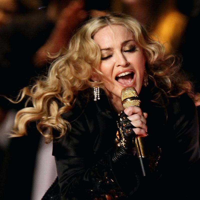 Madonna sings into a golden microphone during the Super Bowl halftime show